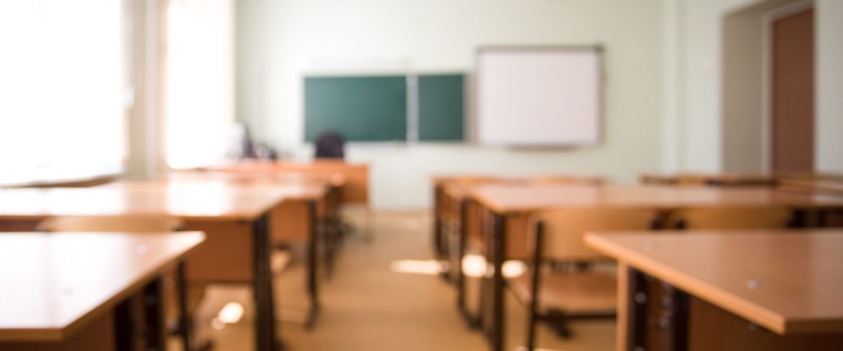 School classroom in blur background without young student. Blurry view of class room no kid or teacher with chairs and tables in campus.